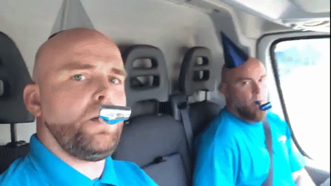 Two men blowing birthday kazoos