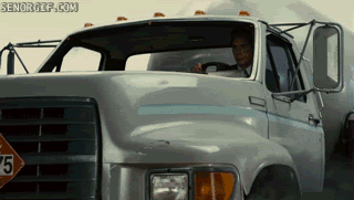 Bloke getting out of a moving truck to stand on a moving car