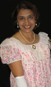 Keira with a gorgeous smile, wearing a lovely white and pink dress with long white gloves.