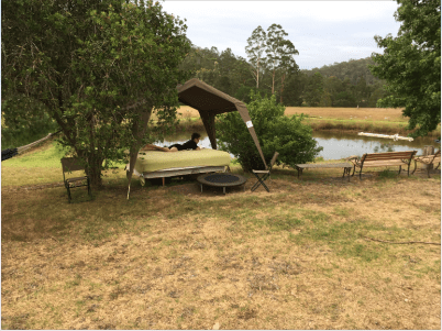 Fave reading spot on an outdoor bed under a tent next to a dam.