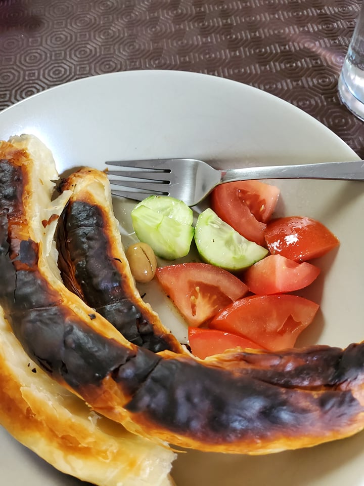 Burnt pie accompanied with tomatoes, cucumbers and a measly olive. Fork in plate. No tablecloth over my table protector. 

I think I need a protector too. 
